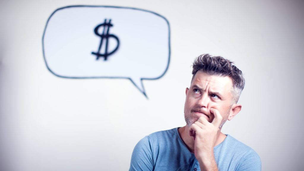 How Much Do I Need to Retire? A Financial Pro Breaks It Down A man appears to be thinking and has a thought bubble above of his head with a dollar sign in it.