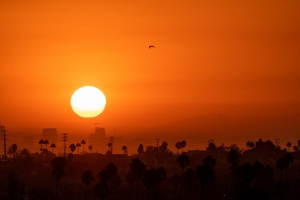Protect Your Retirement From Extreme Weather Events Late Summer Sunrise over Los Angeles - 9/7/2022: A hot summer sun rises over Los Angeles during the end of summer heatwave.