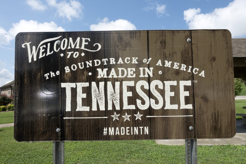 The 10 Cheapest Places to Live in Tennessee wooden sign that reads "Welcome to the soundtrack of America made in Tennessee"