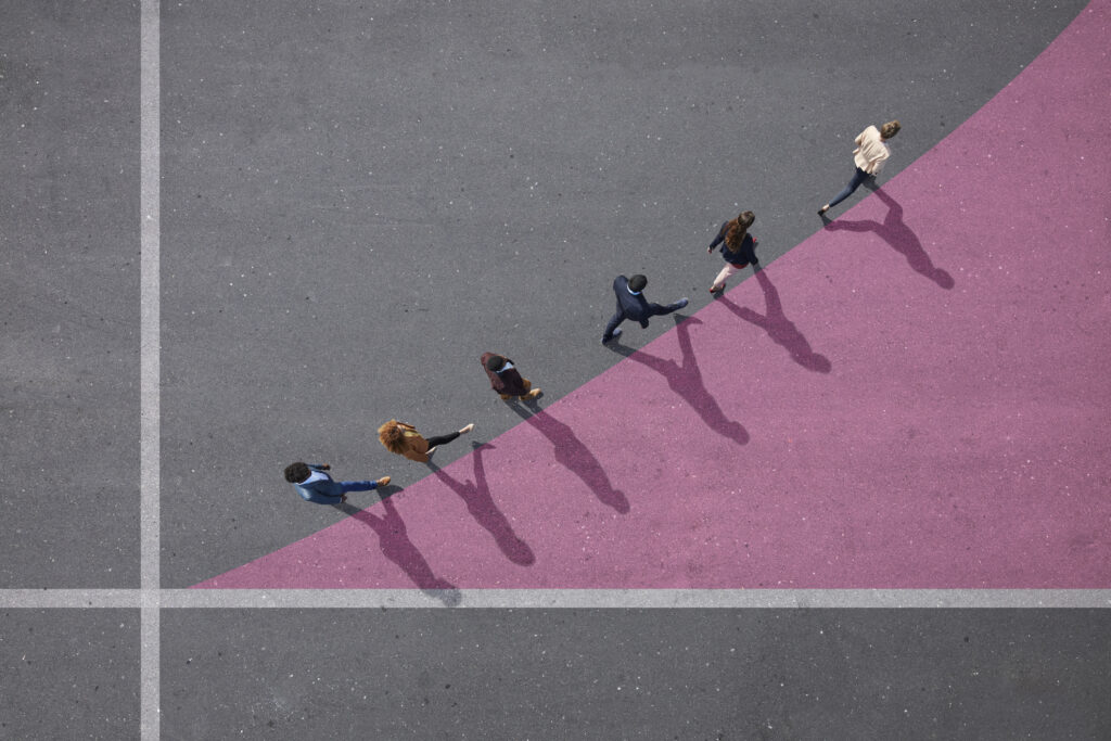 six people walking in single file along the top line of a pink chalked triangle