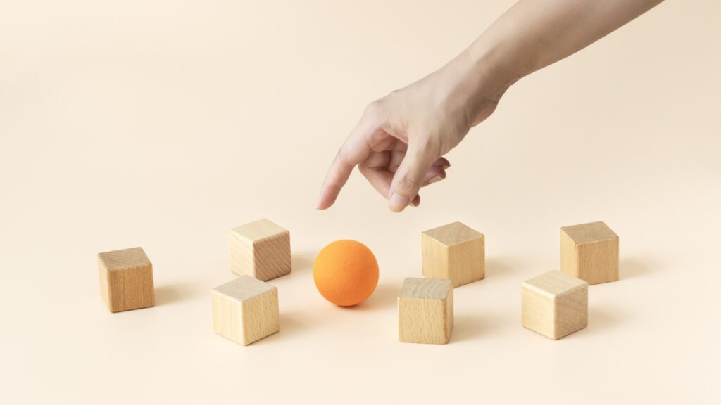 Four Tax-Efficient Ways to Ditch Concentrated Stock Holdings A large orange sphere surrounded by smaller wooden blocks.