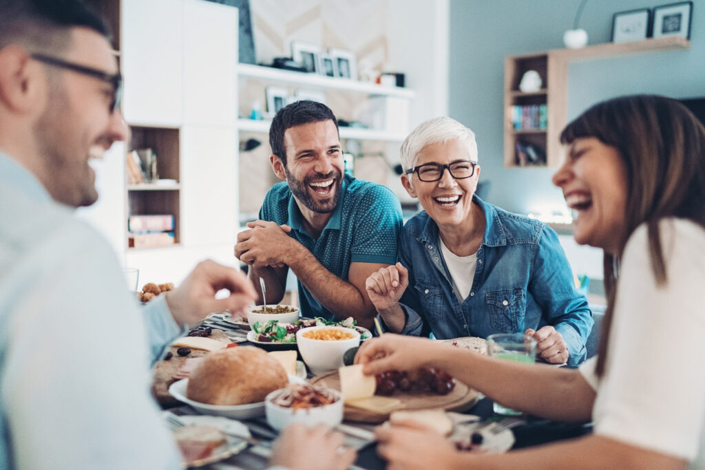 Protect Your Heart: The Surprising Power of this Simple Treatment A group of adults is laughing over a meal. They all have great teeth.