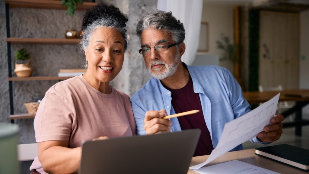 Tactical Roth Conversions: Now Is a Critical Window for Retirees An older couple work on paperwork at their kitchen table.