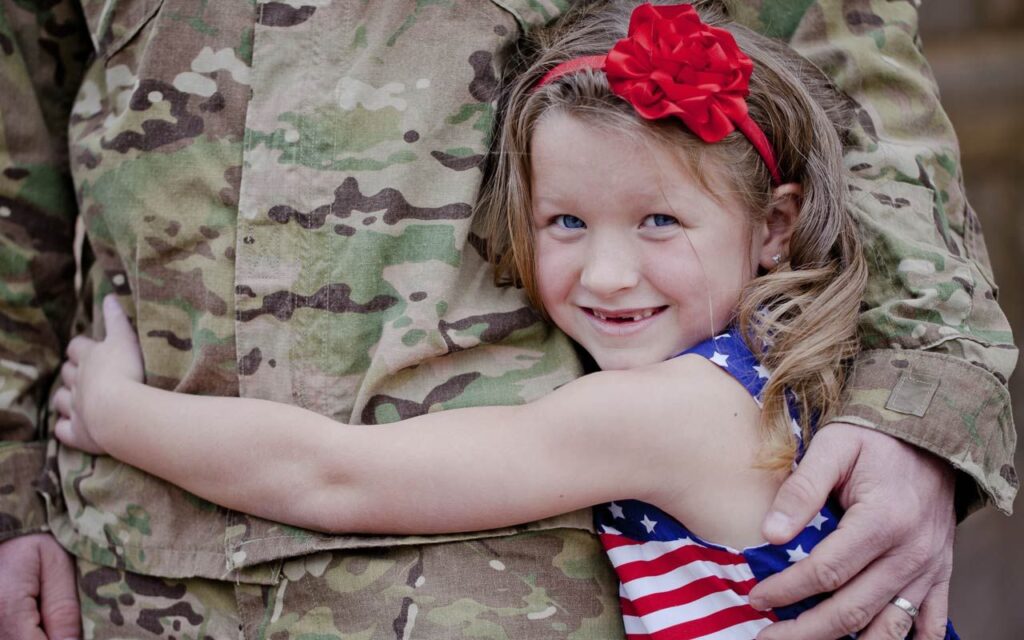Four Military Benefits That Have Helped My Family Child hugging a military service member.