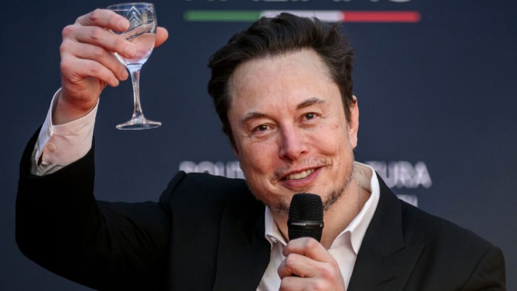 What Musk's $1 Trillion Pay Package Means for Tesla Stock Elon Musk holds a glass of wine.