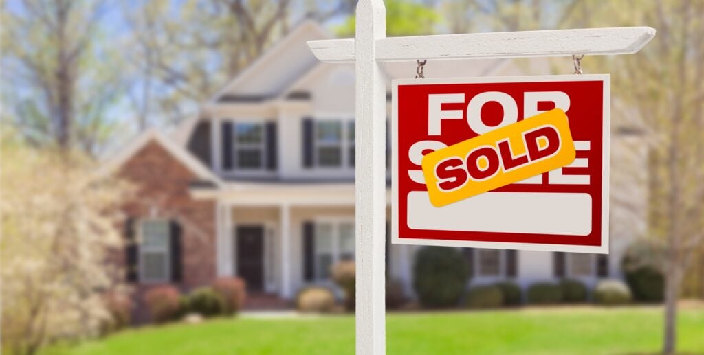 for sale sign sold in front of home