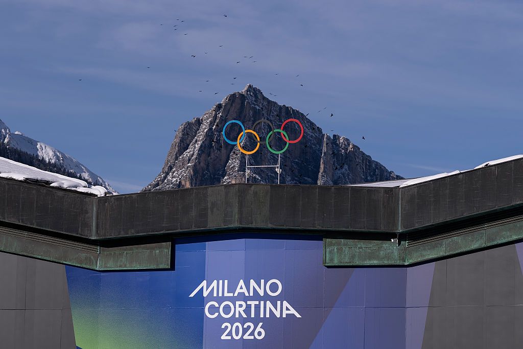 The Olympic Rings are set in front of surrounding mountains at Cortina Curling Olympic Stadium
